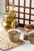 Close Up of Sujeonggwa Persimmon Punch with Ice and Dried Persimmons in a Ceramic Cup, South Korean Drink photo