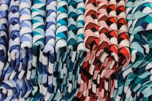 Detailed close up view on samples of cloth and fabrics in different colors found at a fabrics market photo
