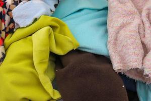 Detailed close up view on samples of cloth and fabrics in different colors found at a fabrics market photo