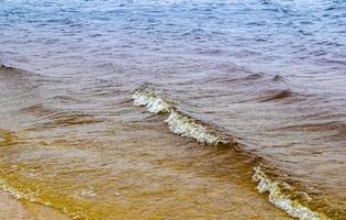 Detailed close up view on water surfaces with ripples and waves and the sunlight reflecting at the surface photo