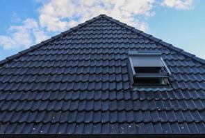 Open roof window in velux style with black roof tiles. photo