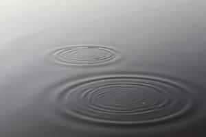 Detailed close up view on water surfaces with ripples and waves and the sunlight reflecting at the surface photo