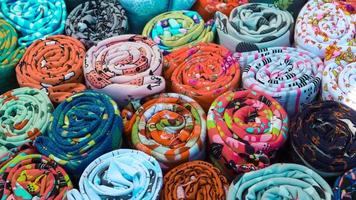 Close up view on rolled samples of cloth and fabrics in different colors found at a fabrics market.. photo