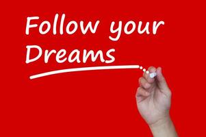 Follow your dreams text written on red cover background. Life inspirational concept photo