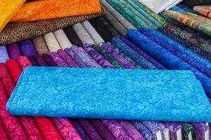 Detailed close up view on samples of cloth and fabrics in different colors found at a fabrics market photo