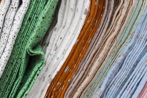 Detailed close up view on samples of cloth and fabrics in different colors found at a fabrics market photo