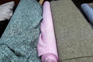 Detailed close up view on samples of cloth and fabrics in different colors found at a fabrics market photo