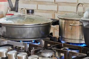 Preparing food in frying pan and casseroles on the gas stove in the kitchen. Home cooking concept photo