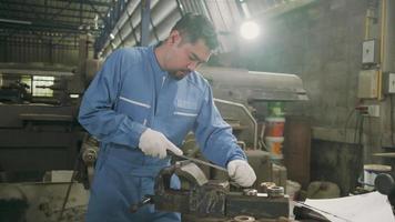 um trabalhador de engenheiro industrial masculino asiático profissional trabalha em um uniforme de segurança com ferramentas de precisão de metalurgia, tornos mecânicos e oficina de peças de reposição na fábrica de fabricação de aço. video