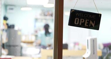 On the door of a cafe there is an open sign. video