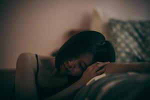 una adolescente desconsolada se sienta en el dormitorio y se arrepiente. sintomas depresivos. foto