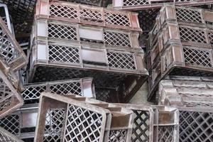 Close up on a pile of used grey plastic cargo packaging crates background. photo