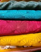 Detailed close up view on samples of cloth and fabrics in different colors found at a fabrics market photo