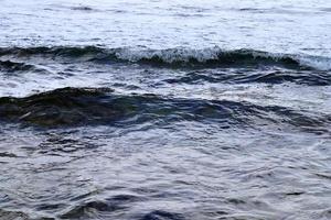 Detailed close up view on water surfaces with ripples and waves and the sunlight reflecting at the surface photo