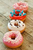 Colorful donuts on wooden table photo