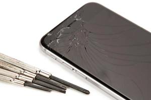 Broken smartphone and small screwdrivers for repair photo