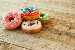 Colorful donuts on wooden table photo