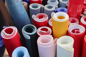 Close up view on rolled samples of cloth and fabrics in different colors found at a fabrics market.. photo