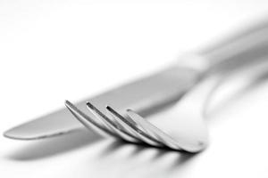 The metal shiny fork and knife on a white background. photo