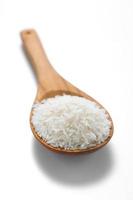arroz jazmín blanco en la cuchara de madera foto