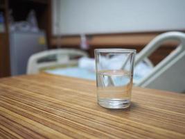 un vaso de agua sobre una mesa en una habitación del hospital foto
