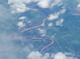 Aerial view of lands and clouds seen through airplane window photo