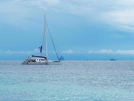 hermoso paisaje marino de superficie azul brillante con yate blanco flotante foto