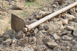 Close-up of dry soil and hoe, prepare for gardening photo