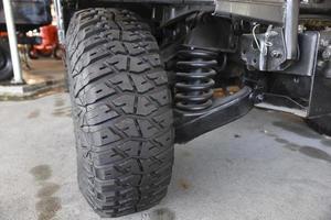 Close-up new military jeep tire and car suspension of an vintage jeep photo