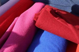 Close up view on samples of cloth and fabrics in different colors found at a fabrics market photo