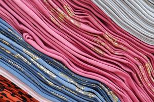 Detailed close up view on samples of cloth and fabrics in different colors found at a fabrics market photo