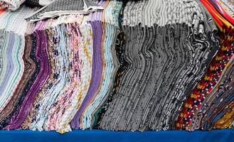 Close up view on samples of cloth and fabrics in different colors found at a fabrics market photo