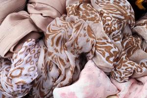 Detailed close up view on samples of cloth and fabrics in different colors found at a fabrics market photo