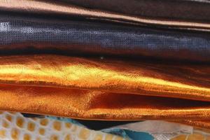 Detailed close up view on samples of cloth and fabrics in different colors found at a fabrics market photo