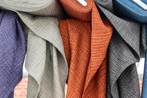 Detailed close up view on samples of cloth and fabrics in different colors found at a fabrics market photo