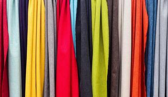 Detailed close up view on samples of cloth and fabrics in different colors found at a fabrics market photo