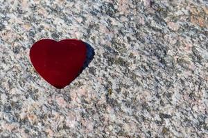 Romantic red love heart lying on a detailed granite background photo