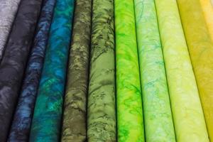 Detailed close up view on samples of cloth and fabrics in different colors found at a fabrics market photo