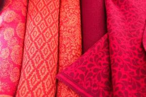 Detailed close up view on samples of cloth and fabrics in different colors found at a fabrics market photo