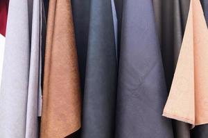 Detailed close up view on samples of cloth and fabrics in different colors found at a fabrics market photo