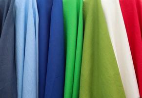 Detailed close up view on samples of cloth and fabrics in different colors found at a fabrics market photo