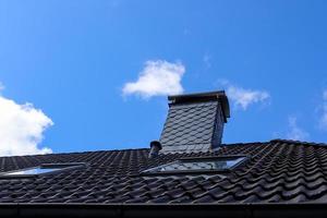 Roof window in velux style with black roof tiles. photo
