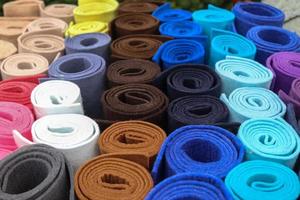 Close up view on rolled samples of cloth and fabrics in different colors found at a fabrics market.. photo