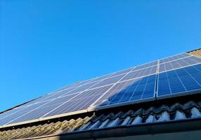 Solar panels producing clean energy on a roof of a residential house photo