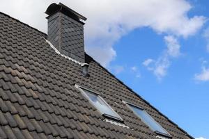 Roof window in velux style with black roof tiles. photo