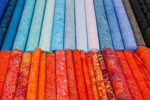 Detailed close up view on samples of cloth and fabrics in different colors found at a fabrics market photo
