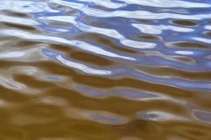 vista detallada de las superficies de agua con ondas y ondas y la luz del sol reflejada en la superficie foto