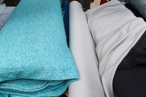 Detailed close up view on samples of cloth and fabrics in different colors found at a fabrics market photo