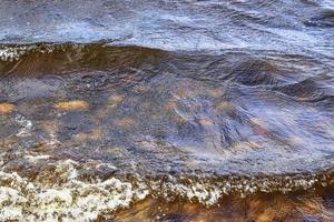 vista detallada de las superficies de agua con ondas y ondas y la luz del sol reflejada en la superficie foto