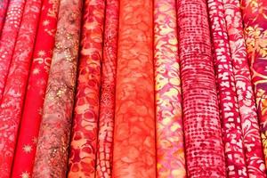 Detailed close up view on samples of cloth and fabrics in different colors found at a fabrics market photo